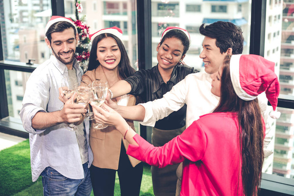 Group of office workers celebrating Christmas and New Year with clink glasses and drink wine together with happy and smile in office. Concept of the celebration of the company party. - Foto, imagen
