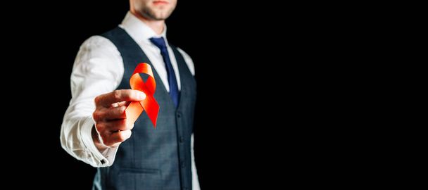 Dzień Hiv. Czerwona wstążka w hiv dzień świata odizolowany na czarnym tle. Człowiek z AIDS i symbolem raka. Koncepcja starzenia się miesiąca - Zdjęcie, obraz