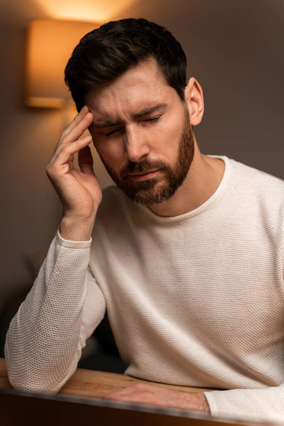 Young tired stressed overworked businessman freelancer exhausted after hard work, suffering from migraine headache at home. Deadline, fired worker, debt, problems concept  - Fotoğraf, Görsel