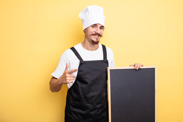 chef hombre mirando emocionado y sorprendido señalando a un lado - Foto, imagen