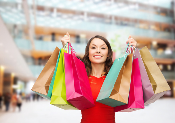 smiling woman with colorful shopping bags - Foto, imagen