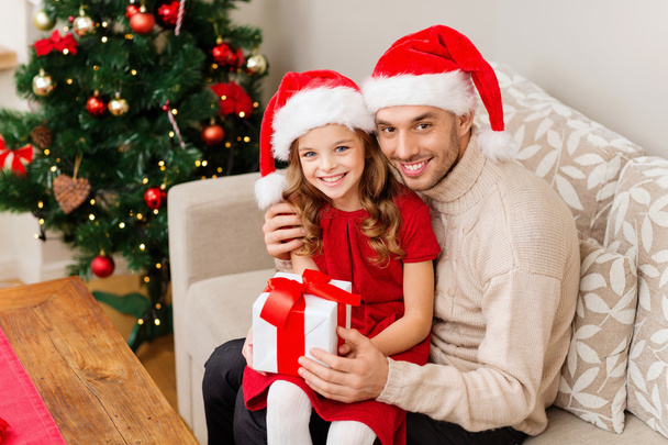 smiling father and daughter holding gift box - Фото, изображение