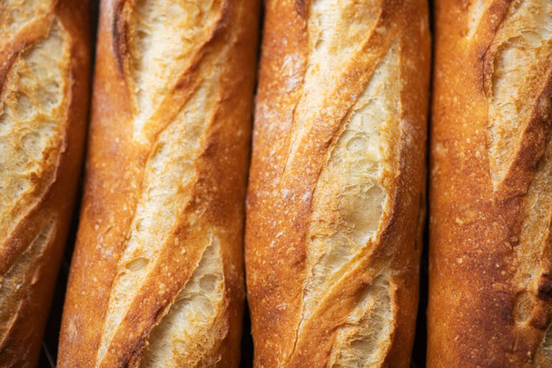 Batch of freshly baked baguettes background. Close up. - Zdjęcie, obraz