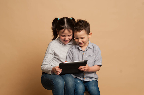 children read and play in the tablet, children look at the computer - Фото, зображення
