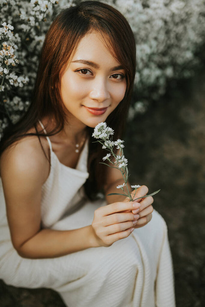 Portrait of thai woman sitting in white flower field - Fotografie, Obrázek