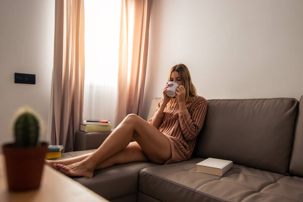 blonde woman drinks coffee relaxed at home - Φωτογραφία, εικόνα