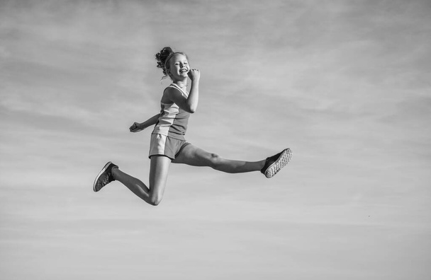 cheerful child athlete or gymnast jump on sky background, energy - Fotoğraf, Görsel