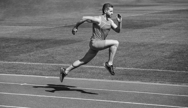 Sporcu koşucu dışarıda. Sağlık hizmeti. Enerji. Kaslı adam başarıya koşar. Stadyumda koşan bir adam. Spor ve sağlıklı yaşam tarzı rutini. Spor antrenmanı. Erkek sporcu sabah egzersizi yapar. - Fotoğraf, Görsel