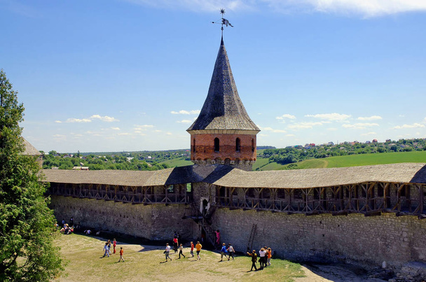 Kamyanets Podilskyi, Ukraine: Kamianets-Podilskyi Castle, the main tourist attraction of the city. View of the castle wall and tower with fields and the city behind. - Zdjęcie, obraz
