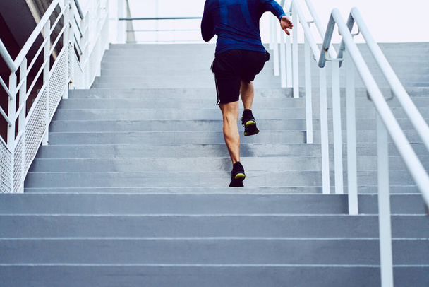 Fitness, health, and sport concept. Athletic man running upstairs - Fotoğraf, Görsel