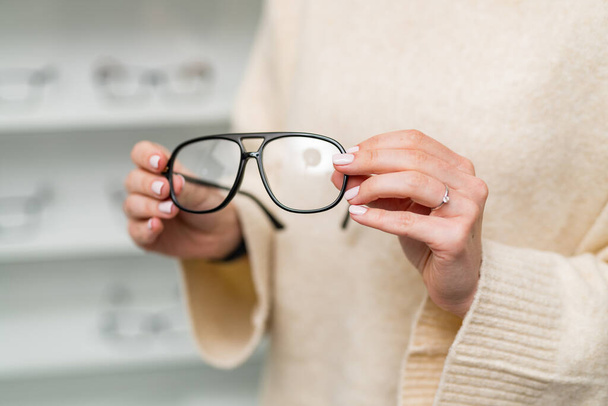 Eyewear modern glasses with stylish lens. Stylish eyeglasses holding in hands. Stock photo - 写真・画像