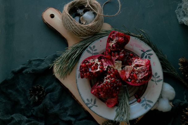 christmas food , red pomegranate on a dark background - Фото, изображение