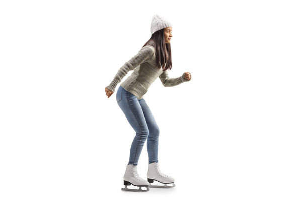 Full length profile shot of a young casual woman ice skating isolated on white background - Фото, изображение