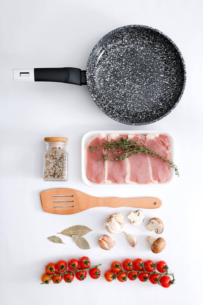Black marble frying pan with products on light grey background, top view - Φωτογραφία, εικόνα