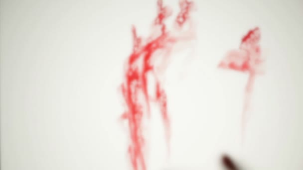 αίμα αλείψει defocused χέρι πίσω από το παγωμένο ποτήρι - Πλάνα, βίντεο