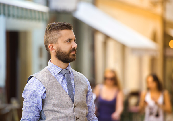Businessman with beard walking in town - Foto, afbeelding