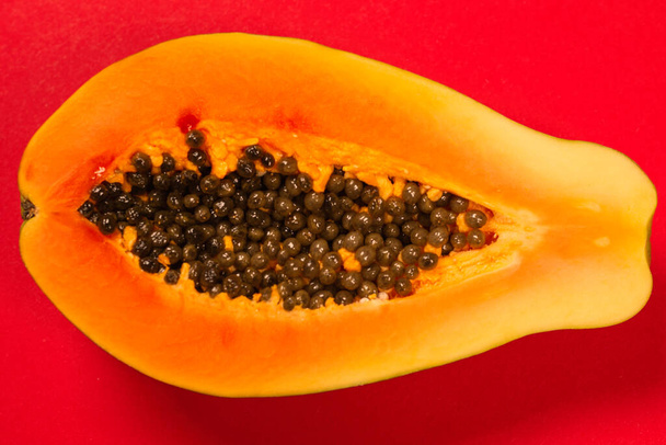 Fruta de la papaya sobre fondo naranja. Fruta tropical. Mitad papaya.  - Foto, imagen