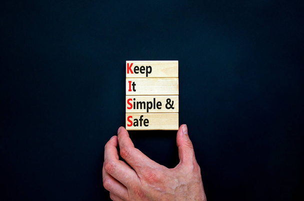 KISS keep it simple and safe symbol. Concept words KISS keep it simple and safe wooden blocks. Beautiful black table, black background. Business and KISS keep it simple and safe concept. Copy space. - Photo, Image