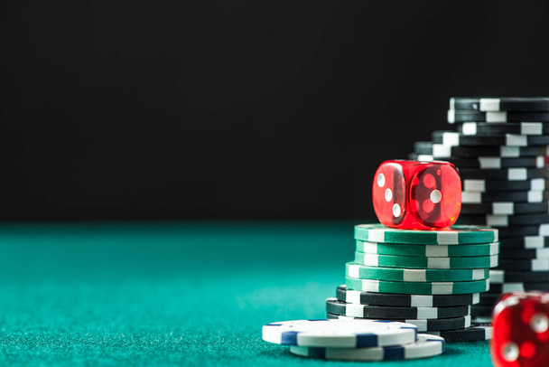 Fichas de Poker y Dices en la mesa de póquer verde. Fondo del Casino. - Foto, Imagen