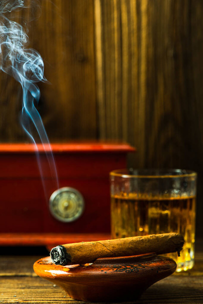 Cuban Cigar Smoking in Ashtray on Wooden Table. - Foto, imagen