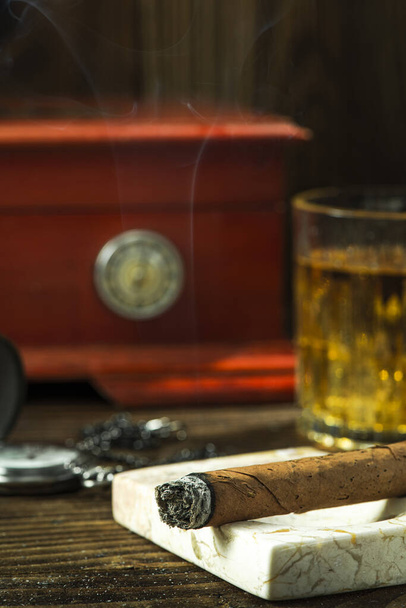 Smoking Cuban Cigar. Tobacco and Humidor on Wooden Table. - Foto, imagen