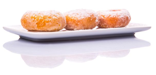 Kotitekoinen donitsi sokerilla täytteet valkoisella lautasella valkoisella pohjalla
 - Valokuva, kuva