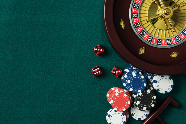 Roulette Wheel and Casino Chips on Green Table. Copyspace Background. - Fotó, kép