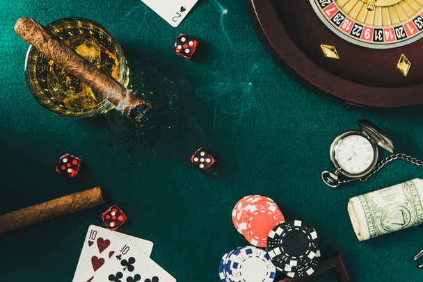 Τσιγάρο καπνίσματος ενώ παίζουν ρουλέτα ή πόκερ παιχνίδι για τα χρήματα. - Φωτογραφία, εικόνα