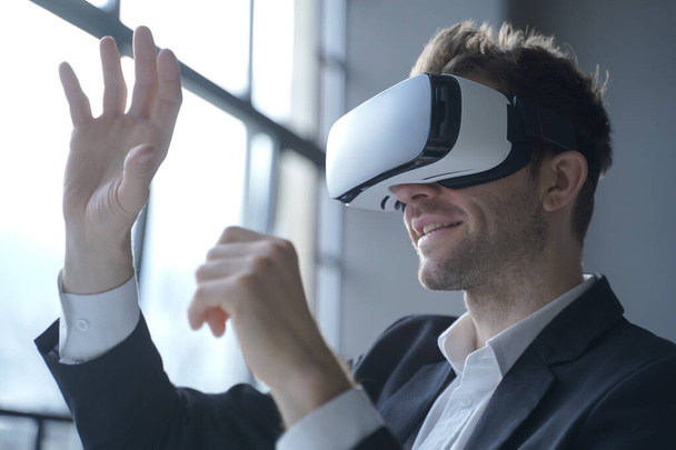 Europian man office medewerker draagt formele pak en VRheadset opgewonden van het ervaren van virtual reality - Foto, afbeelding