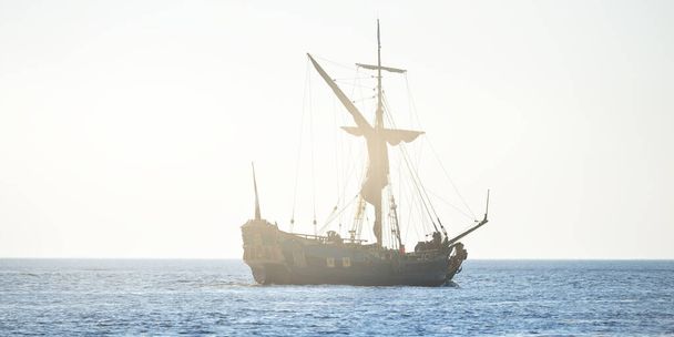 XVIII-wieczny jacht żaglowy na otwartym morzu o zachodzie słońca, zbliżenie. Holandia. Stary, wysoki statek. Rekreacja, wakacje, rejs, historyczne odtwarzanie, przeszłość, historia - Zdjęcie, obraz