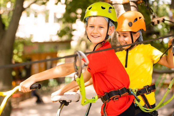 Adventure climbing high wire park - mały chłopiec na kursie w górskim hełmie i sprzęcie bezpieczeństwa - Zdjęcie, obraz