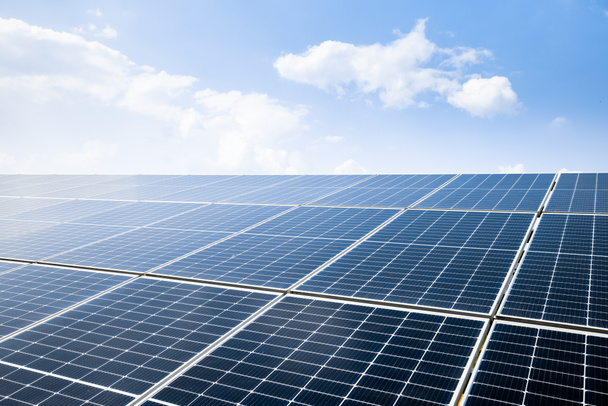 Photovoltaic modules of huge solar panels with clear blue sky and sun on background - Photo, image
