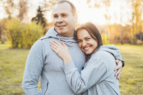 Close-up portrait of a smiling middle-aged couple posing in the park. - Valokuva, kuva