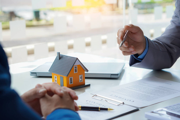 Home dealers are recommending homes to new owners after agreeing to a contract to sell the home. Renting and Buying a House Real estate agent explaining to clients about ownership agreements - 写真・画像