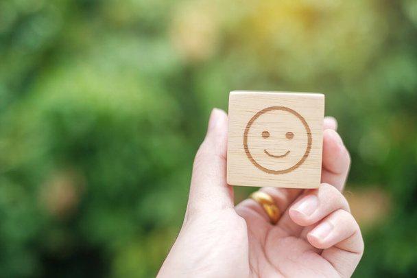 木製のブロック上の笑顔の感情の顔のシンボル。サービス評価、ランキング、顧客レビュー、満足度、評価、フィードバックの概念 - 写真・画像