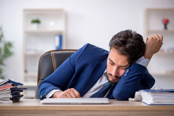 Young male employee extremely tired in the office - Foto, Bild