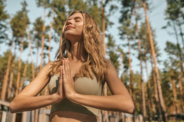 Cute blonde woman practising yoga outside and looking relaxed - Zdjęcie, obraz