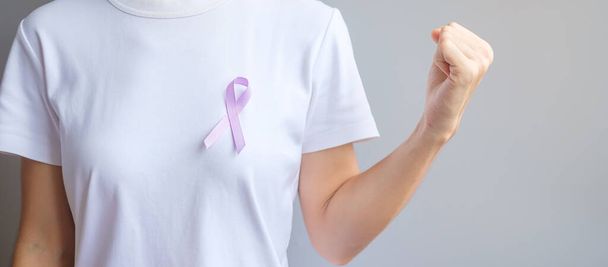 Παγκόσμια ημέρα καρκίνου (4 Φεβρουαρίου). Μωβ κορδέλα λεβάντας για την υποστήριξη ανθρώπων που ζουν και αρρωσταίνουν. Υγειονομική και ιατρική έννοια - Φωτογραφία, εικόνα