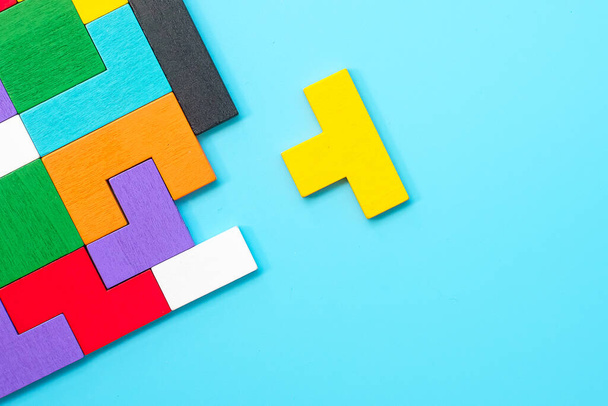 colorful wood puzzle pieces on blue background, geometric shape block. Concepts of logical thinking, Conundrum, solutions, rational, strategy, world logic day and Education - Фото, изображение