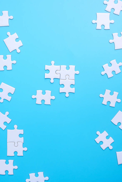 Skupina bílých puzzle kousky na modrém pozadí. Koncepce řešení, poslání, úspěch, cíle, spolupráce, partnerství, strategie a puzzle den - Fotografie, Obrázek