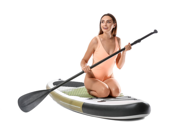 Beautiful young woman with board for sup surfing and oar on white background - Foto, immagini