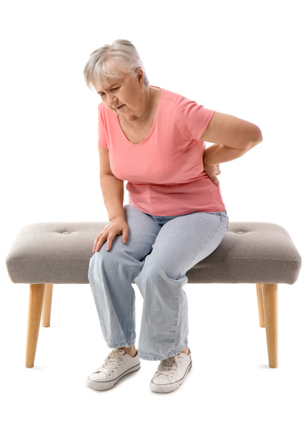 Senior woman in t-shirt suffering from back pain on white background - Photo, Image