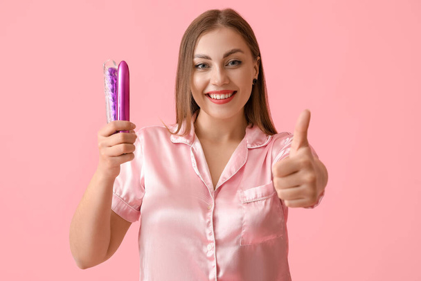 Nuori nainen seksileluja osoittaa peukalo-up väri tausta - Valokuva, kuva