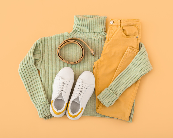 Female clothes, shoes and belt on color background - Foto, imagen