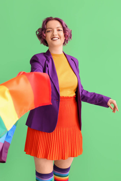 Mujer joven con bandera LGBT sobre fondo verde - Foto, Imagen