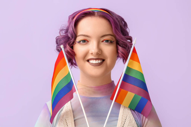 Young woman with LGBT flags on color background - Photo, Image