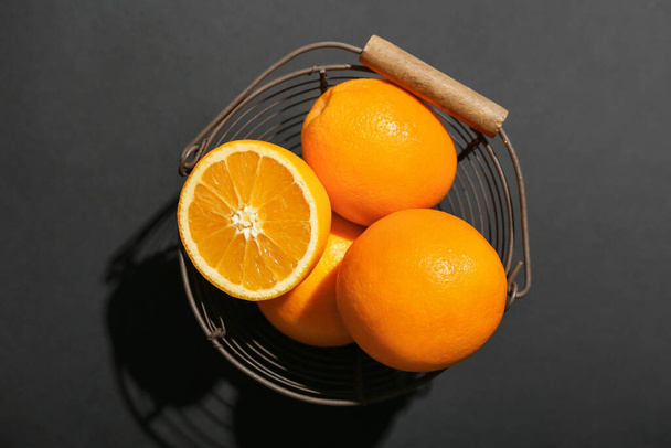 Basket with fresh oranges on dark background - Foto, immagini
