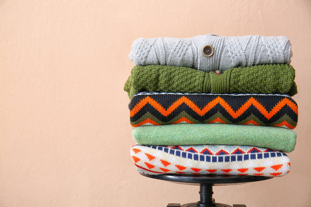 Stack of stylish sweaters on color background - Foto, Imagem