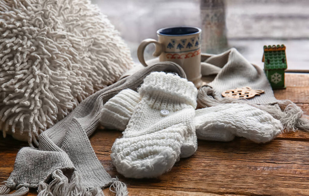 Warm gloves and scarf on windowsill - Фото, изображение
