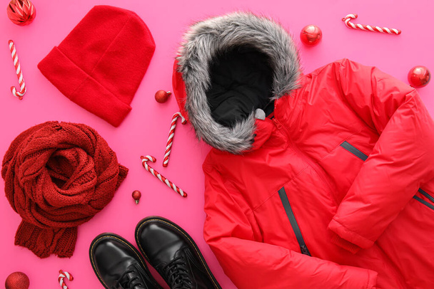 Warm clothes, shoes and Christmas decor on color background - Фото, изображение